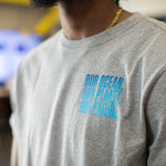 Close up of the logo on the front left chest of heather gray t-shirt that says, Our Ocean, Our Planet, Our Future.  Logo is different shades of blue.