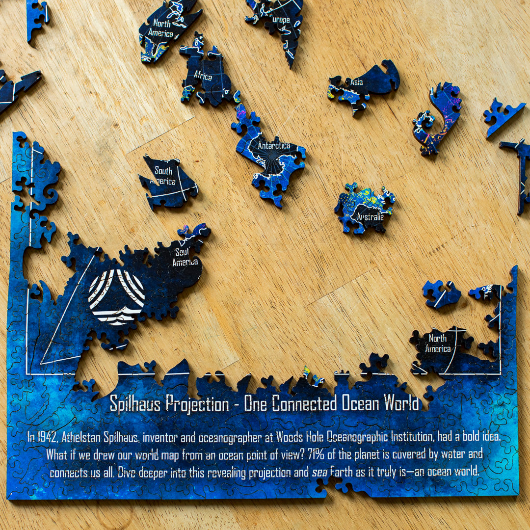 A close-up photo of the map being put together with the text about the Spilhaus Projection at the bottom of the  puzzle.